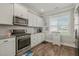 Bright kitchen featuring stainless steel appliances, granite countertops, and white cabinets at 60 Heart Pine Dr, Wendell, NC 27591