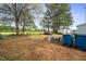 Spacious backyard featuring lush green grass and mature trees with parked car at 607 E Granville St, Dunn, NC 28334