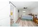 Bedroom features wood-look flooring, ceiling fan, and ensuite bathroom with a barn door at 607 E Granville St, Dunn, NC 28334