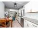 Bright kitchen featuring white cabinets, granite countertops, stainless steel appliances, and wood-look floors at 607 E Granville St, Dunn, NC 28334