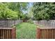 Expansive backyard with lush green grass, wooden fence, and charming shed in the background at 616 Dorothea Dr, Raleigh, NC 27603