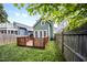 Grassy backyard with a wooden deck leading to the house, surrounded by a privacy fence at 616 Dorothea Dr, Raleigh, NC 27603