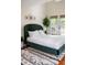 Inviting bedroom featuring a green velvet bed, patterned rug, and access to a private deck at 616 Dorothea Dr, Raleigh, NC 27603