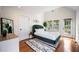 Bright bedroom with hardwood floors, a green bed, and double doors to the backyard at 616 Dorothea Dr, Raleigh, NC 27603
