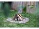 Cozy fire pit area with stacked firewood and stone border in a peaceful backyard setting at 616 Dorothea Dr, Raleigh, NC 27603