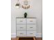 Stylish white dresser with light wood accents and unique wall decor creates a modern aesthetic at 616 Dorothea Dr, Raleigh, NC 27603