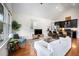 Bright living room with hardwood floors, a white sofa, and an open concept kitchen at 616 Dorothea Dr, Raleigh, NC 27603