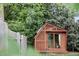 Charming backyard shed featuring a wooden design, glass doors, and serene garden setting at 616 Dorothea Dr, Raleigh, NC 27603