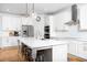 Bright, white kitchen with large island, stainless steel appliances, and modern lighting fixtures at 638 Boulder Point Dr, Chapel Hill, NC 27516