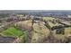 Aerial view of a rural property showcasing fields, trees, and multiple buildings, including a large barn at 754 Epps Clark Rd, Siler City, NC 27344