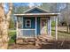Charming blue outbuilding with porch, white trim, a small window, and a cozy atmosphere at 754 Epps Clark Rd, Siler City, NC 27344