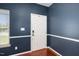 Entryway with an elegant white door, dark blue walls, white trim and hardwood flooring at 8300 Neuse Hunter Dr, Raleigh, NC 27616