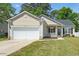 Charming single-story home featuring a front-facing garage and a welcoming porch with a decorative wreath at 8300 Neuse Hunter Dr, Raleigh, NC 27616