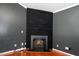 Close-up of a modern fireplace with rustic black wood and a decorative iron grate at 8300 Neuse Hunter Dr, Raleigh, NC 27616