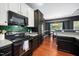 Updated kitchen featuring modern appliances, dark cabinets, and wood flooring at 8300 Neuse Hunter Dr, Raleigh, NC 27616