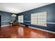 Bright living room showcasing hardwood floors, large windows, and dark blue walls complemented by elegant white trim at 8300 Neuse Hunter Dr, Raleigh, NC 27616