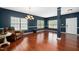 Spacious living room featuring dark blue walls, white trim, hardwood floors, and plenty of natural light at 8300 Neuse Hunter Dr, Raleigh, NC 27616