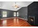 Inviting living room features a dark painted fireplace, hardwood floors and a ceiling fan at 8300 Neuse Hunter Dr, Raleigh, NC 27616