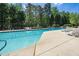 Community pool featuring lounge chairs and mature trees in the background for shade and privacy at 8300 Neuse Hunter Dr, Raleigh, NC 27616