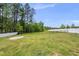 Spacious, fenced-in backyard with a large grassy area and mature trees providing privacy at 86 Buckhaven Ct, Holly Springs, NC 27540
