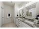 Bathroom with double sinks, granite counters, and decorative mirrors at 86 Buckhaven Ct, Holly Springs, NC 27540