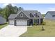 Beautiful exterior featuring stone accents, a three-car garage, and a well-manicured lawn at 86 Buckhaven Ct, Holly Springs, NC 27540