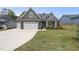 Charming home featuring stone accents, a two-car garage, and well-maintained landscaping at 86 Buckhaven Ct, Holly Springs, NC 27540