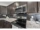 Elegant kitchen with stainless steel appliances, granite countertops, and black subway tile backsplash at 86 Buckhaven Ct, Holly Springs, NC 27540