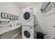 Modern laundry room with stacked washer and dryer, a marble countertop, and a 'Laundry' sign at 86 Buckhaven Ct, Holly Springs, NC 27540