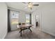 Bright office features two windows, modern ceiling fan, and a wooden desk for a functional workspace at 86 Buckhaven Ct, Holly Springs, NC 27540