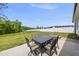 Outdoor patio with dining table and seating, overlooking a large, fenced backyard and lush greenery at 86 Buckhaven Ct, Holly Springs, NC 27540