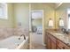 Well-lit bathroom with a soaking tub and vanity, connected to a bedroom with a comfortable bed at 9207 Wooden Rd, Raleigh, NC 27617