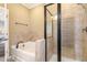 Bathroom featuring a tub, tiled shower stall, and neutral-colored tile surround at 9207 Wooden Rd, Raleigh, NC 27617