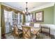 Formal dining room featuring large window, chandelier and table with seating for six at 9207 Wooden Rd, Raleigh, NC 27617