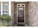 A welcoming front door with brick surround and decorative sidelight providing curb appeal at 9207 Wooden Rd, Raleigh, NC 27617