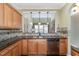 Spacious kitchen featuring granite countertops and stained-wood cabinetry with view to the living room at 9207 Wooden Rd, Raleigh, NC 27617