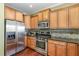 Well-equipped kitchen with stainless steel appliances, wood cabinets, and hardwood floors at 9207 Wooden Rd, Raleigh, NC 27617