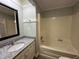 This bathroom features a vanity with a granite countertop, a soaking tub with shower, and neutral paint at 10017 Oakley Rd, Zebulon, NC 27597