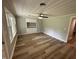 Bright bedroom with wood-look flooring, a ceiling fan, built-in storage, and natural light from a window at 10017 Oakley Rd, Zebulon, NC 27597