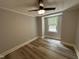 Cozy bedroom with wood-look flooring, a ceiling fan, and a window offering natural light at 10017 Oakley Rd, Zebulon, NC 27597
