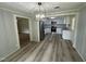 Dining room view leading to a modern white kitchen with stainless steel appliances and gray walls at 10017 Oakley Rd, Zebulon, NC 27597