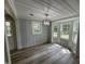 Elegant dining room with wainscoting, wood-look flooring, modern light fixture and many windows at 10017 Oakley Rd, Zebulon, NC 27597