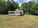 Charming cottage-style home with covered porch and manicured lawn at 10017 Oakley Rd, Zebulon, NC 27597