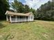 Inviting cottage-style home featuring a covered porch and well-maintained lawn at 10017 Oakley Rd, Zebulon, NC 27597