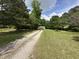 Quaint cottage-style home nestled among mature trees and long gravel driveway at 10017 Oakley Rd, Zebulon, NC 27597