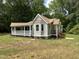 Charming cottage-style home with a covered porch, new grass and manicured landscaping at 10017 Oakley Rd, Zebulon, NC 27597