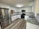 Modern white kitchen featuring granite countertops, stainless steel appliances, and ample cabinet space at 10017 Oakley Rd, Zebulon, NC 27597