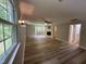 This living room features a fireplace, large windows with views, neutral paint, and plank flooring at 10017 Oakley Rd, Zebulon, NC 27597