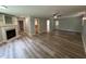 Spacious living room with fireplace, neutral paint, and plank flooring with multiple entryways at 10017 Oakley Rd, Zebulon, NC 27597