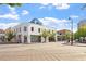 Street view of the building, with its white facade, trees, and surrounding buildings at 101 Morris St # D, Durham, NC 27701